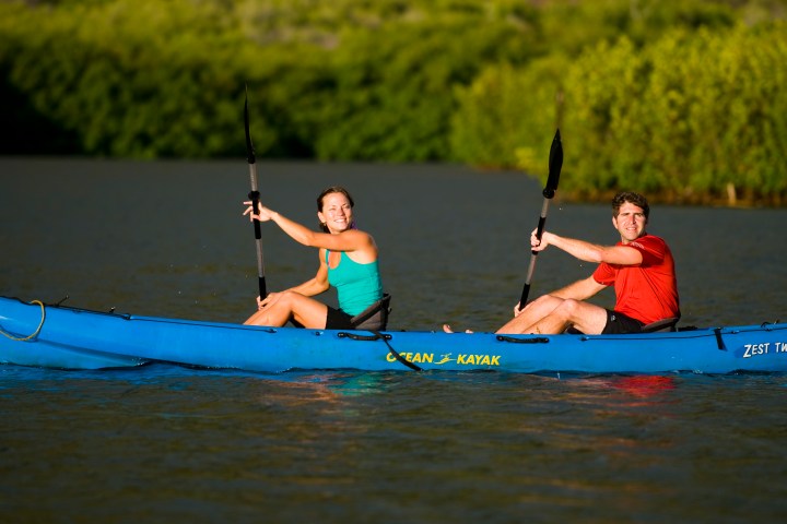 A couple padding down the river on a tour
