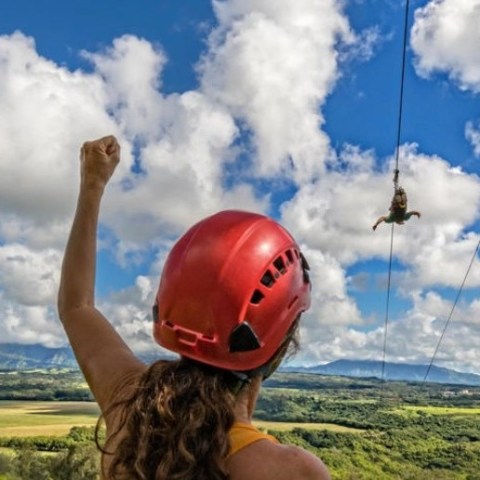 Guest cheering from the Kipu Ranch launch deck as friends ride the FlyLine on the Nui Kauaʻi Zipline tour.