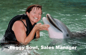  Peggy Sowl, Sales Manager, smiling with a dolphin during an ocean experience in Hawaiʻi