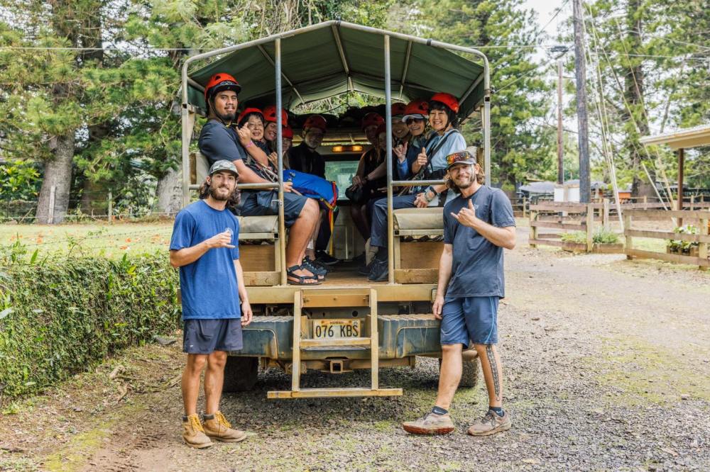 Guests riding in an open air ranch truck during an Outfitters Kauai zipline tour at Kipu Ranch in Lihue