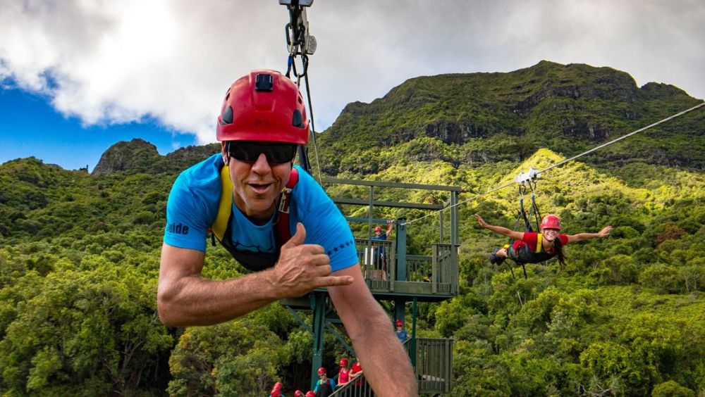Guests ziplining high above lush valleys at Kīpū Ranch on Kauaʻi