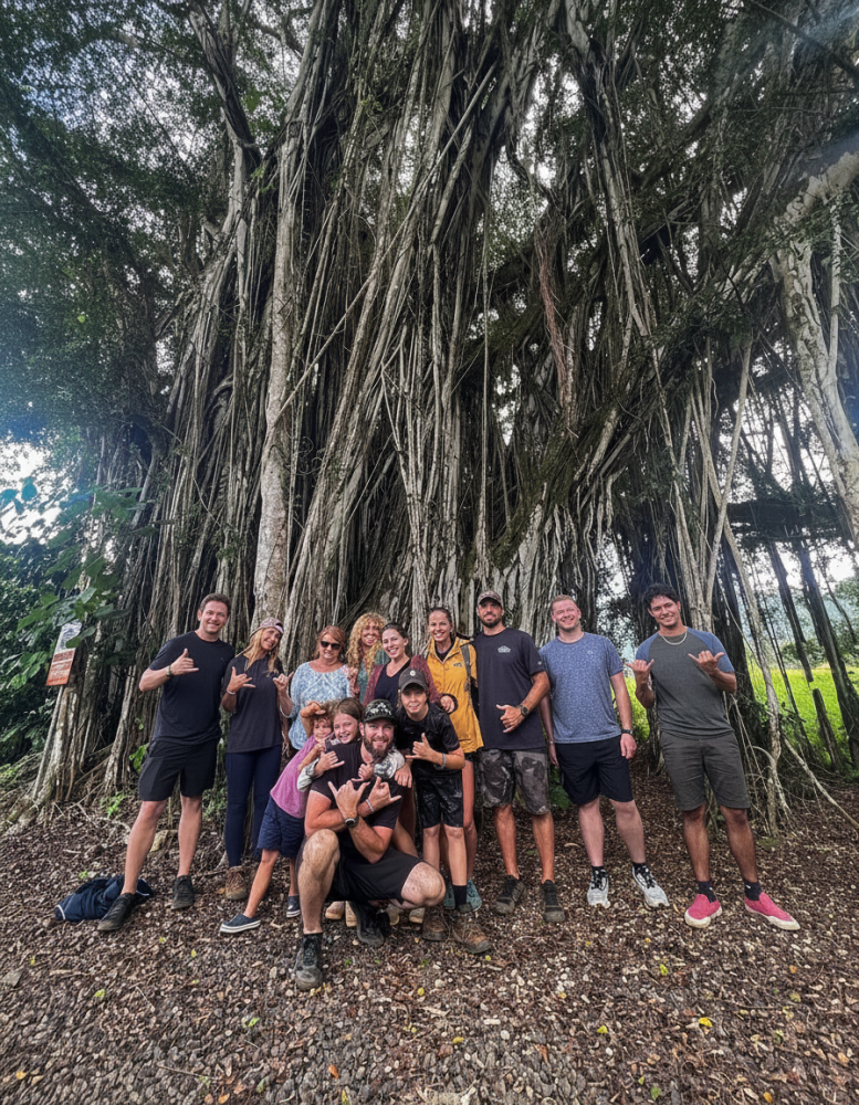 Family in front of large banyan tree on Kipu Ranch after their Zipline Tour with Outfitters Kauai.
