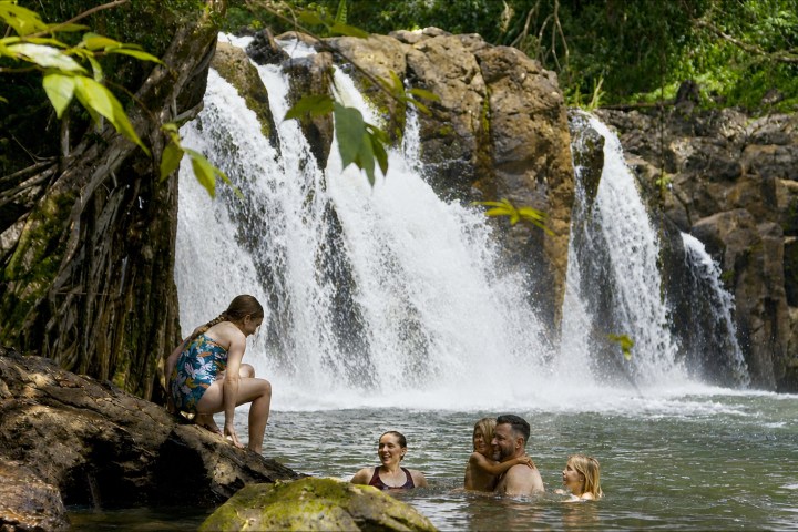 Family enjoying Kīpū Falls during a guided hiking tour at Kīpū Ranch on Kauaʻi, Hawaiʻi.